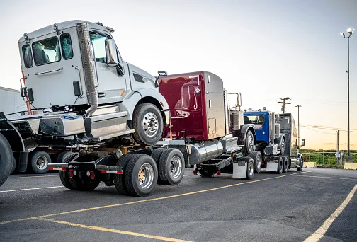 TX Tow Alliance towing two heavy duty trucks on the road